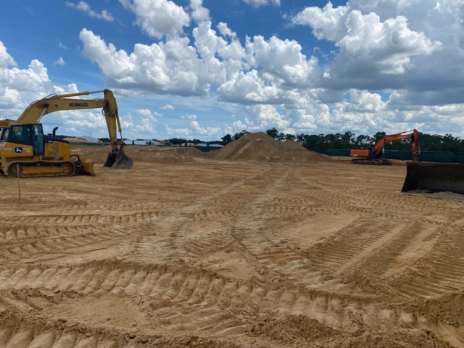 Excavators working across a prepared construction pad