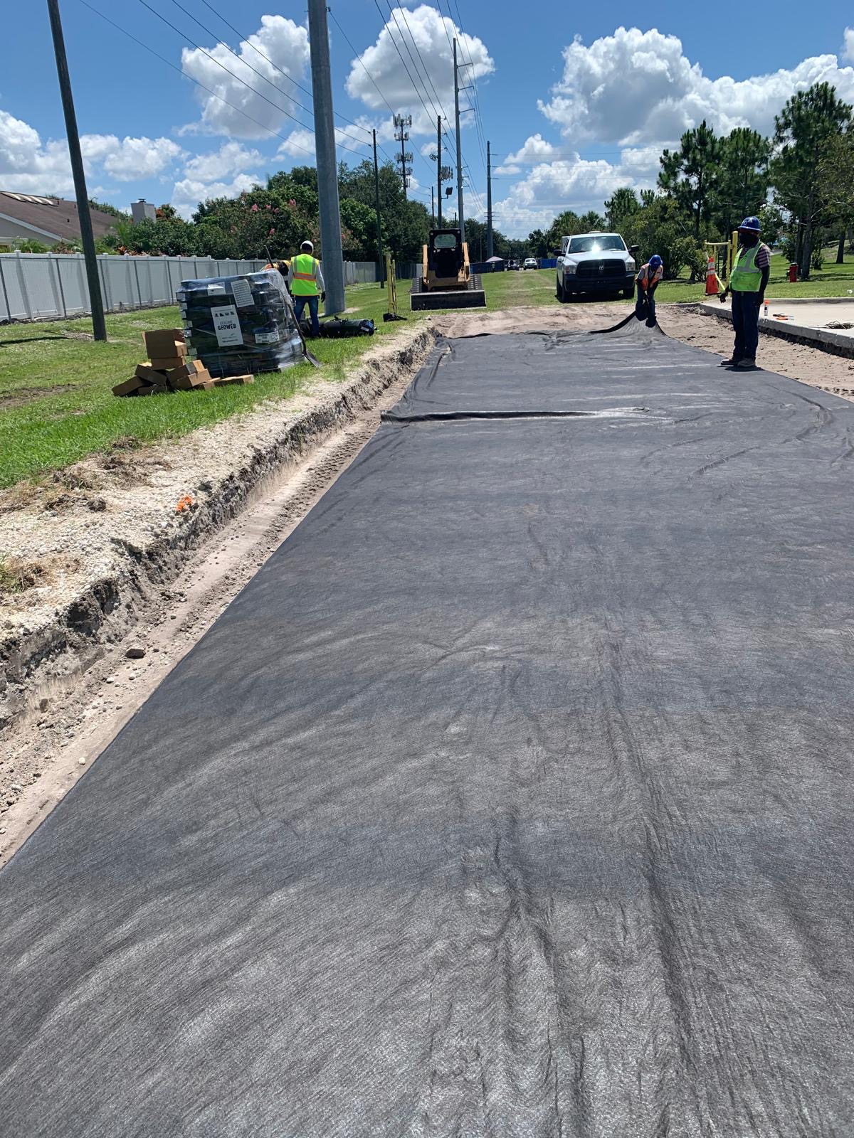 Crew installing roadway fabric on a prepared subgrade