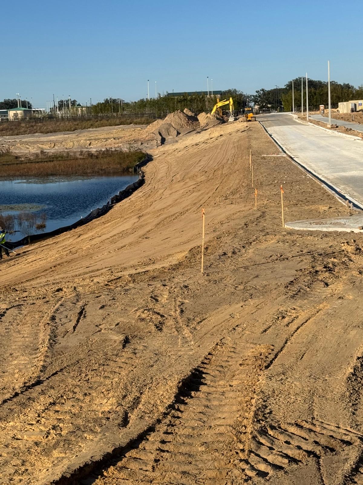 Lake bank grading beside a concrete roadway